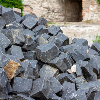 pile-stones-building-materials-stones-masonry-pavement-sidewalk-building-granite-dark-cobblestones_76020-81